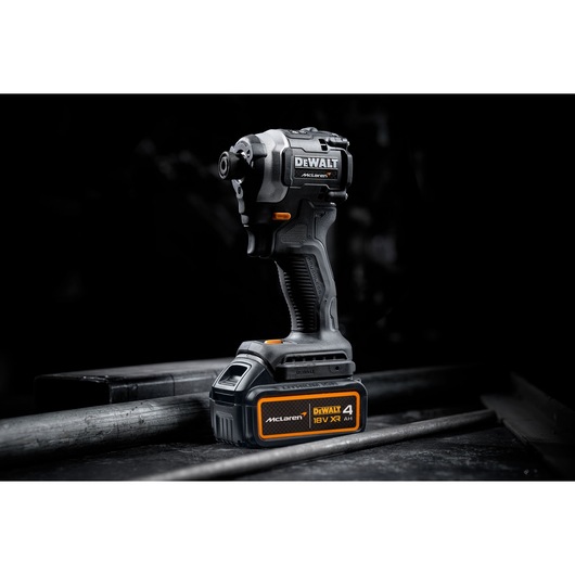 DEWALT/McLaren Impact Driver with 18V XR 4Ah battery 3/4 view in staged dark setting
