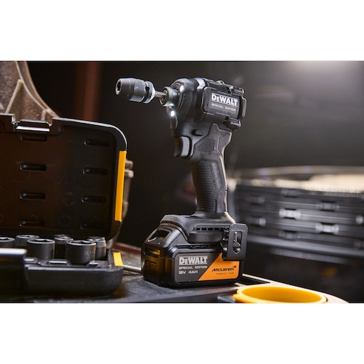 DEWALT x McLaren F1 Team 18V XR Special Edition Impact Driver with 4Ah battery standing next to a socket set
