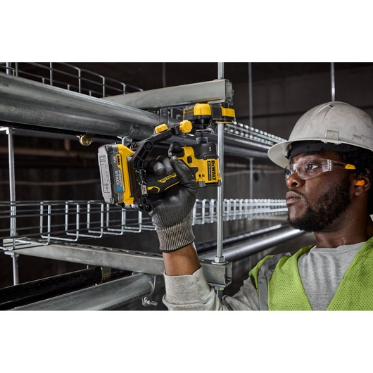 Worker using Dewalt Nut Runner Attachment to lift strut 